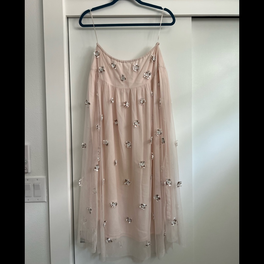 Long soft pink skirt with white and crystal floral attachments.